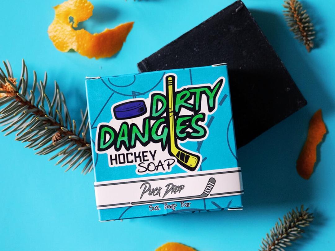 puck drop charcoal pine orange peel and vanilla soap bar on a blue background
