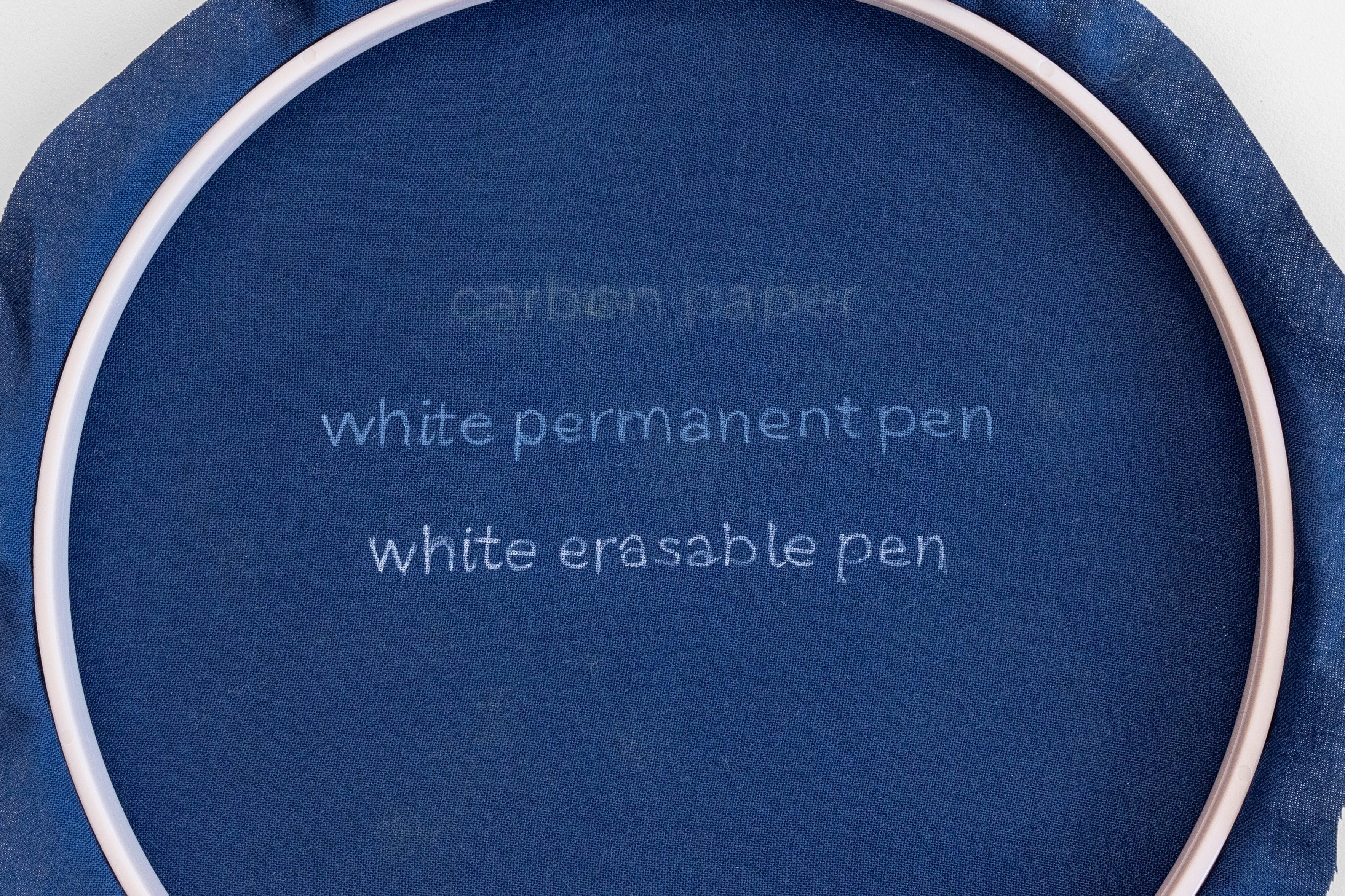 Different lightly-coloured pens are drawn on a hoop with a dark background.