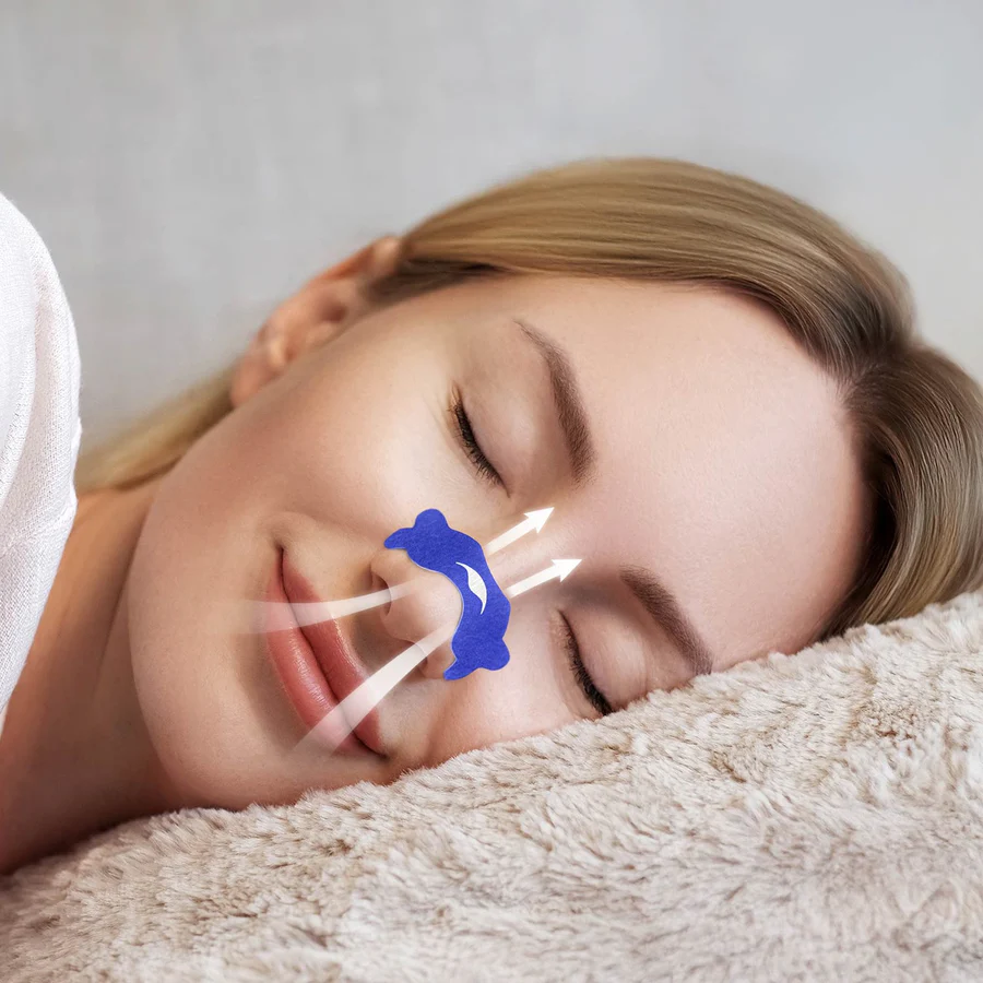 A sleeping woman with a blue nasal strip on her nose to relieve her stuffy nose.