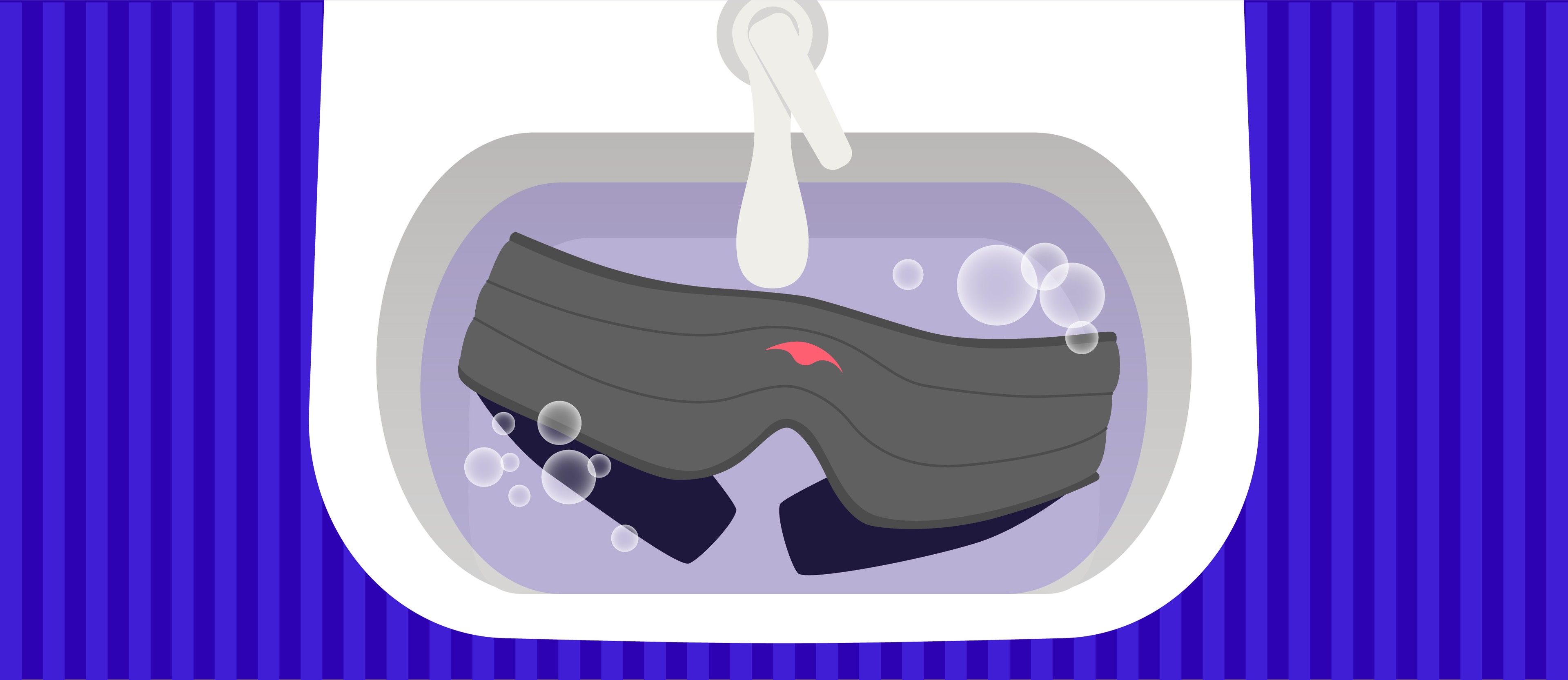 A sink with a dark gray weighted sleep mask submerged in soapy water.