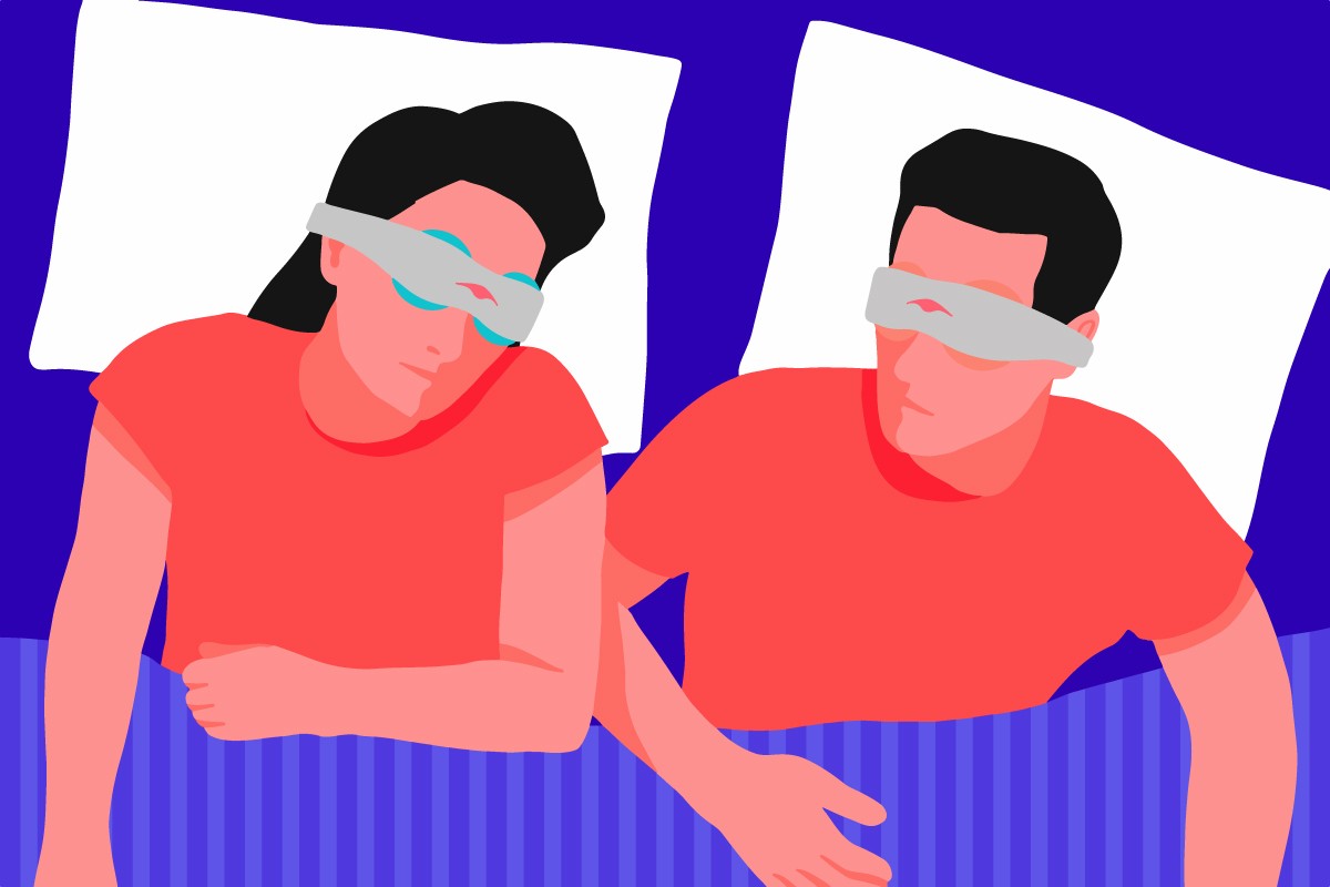 A man and woman wearing compression eye masks lying down in bed. The woman is wearing a cold compression eye mask while the man is wearing a warm compression eye mask.