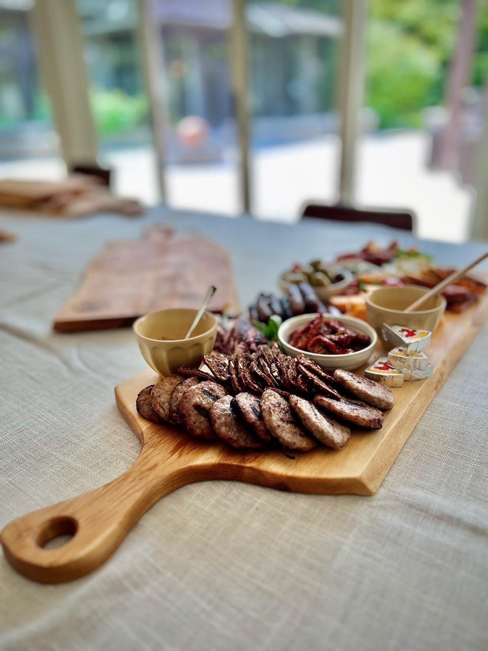 Live edge maple charcuterie board being served full of snacks.