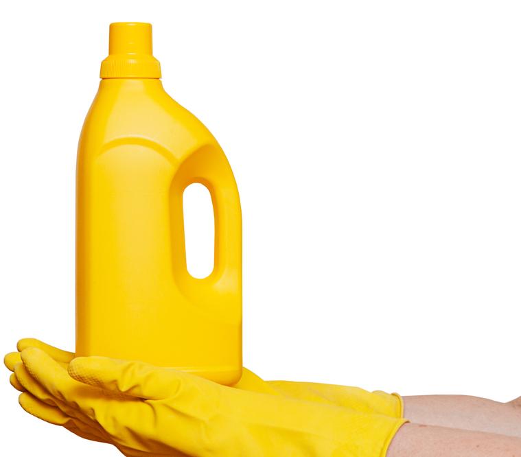 mains avec des gants jaunes qui tiennent un bidon de produit