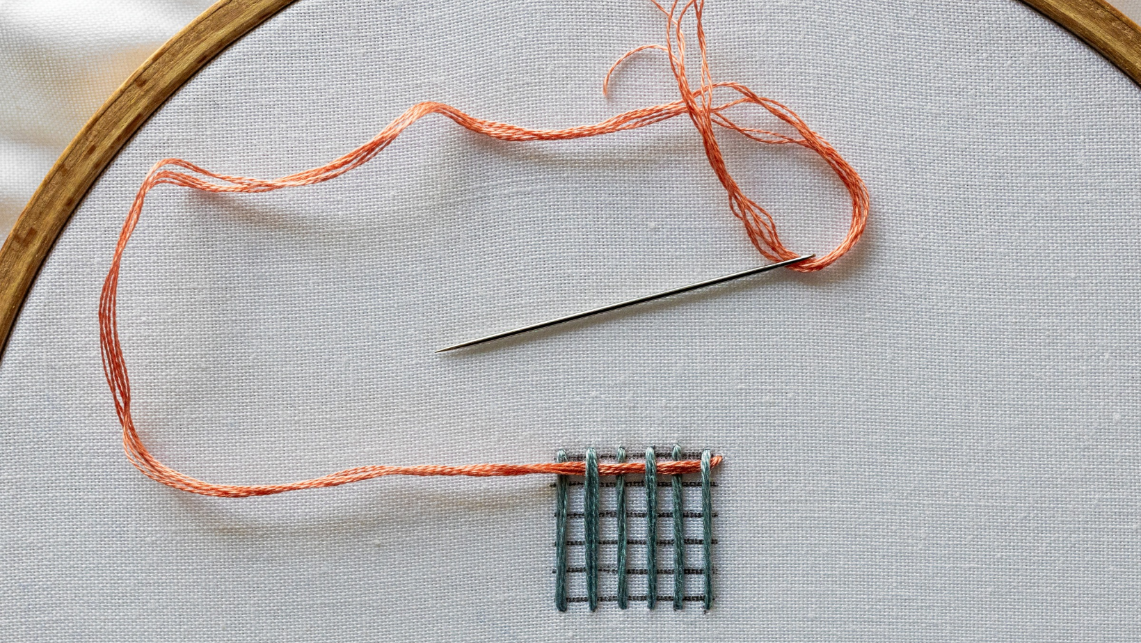 A completed first row of weaving passing over and under the warp threads.