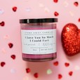 A burgundy wine cellar scented candle candle on a pink background with hearts. I love you so much i could fart