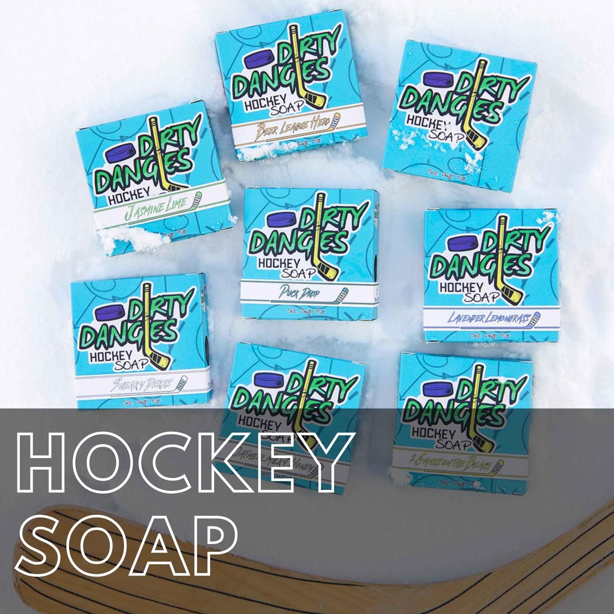 Dirty Dangles hockey soap bars displayed on ice with hockey sticks nearby. Hockey Soap