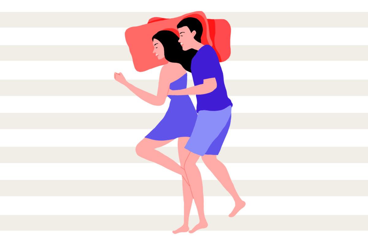 A man and a woman lying in bed in the spooning couple sleeping position.