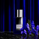 Wolfsbane bottle with purple wolfsbane flowers against a dark pleated curtain