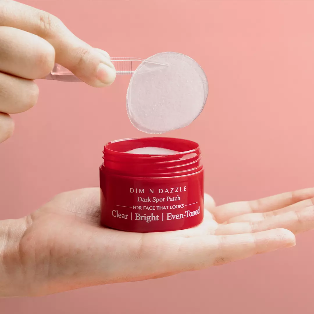 Model lifting Dim N Dazzle Spot Patch out of the jar with the tweezer provided